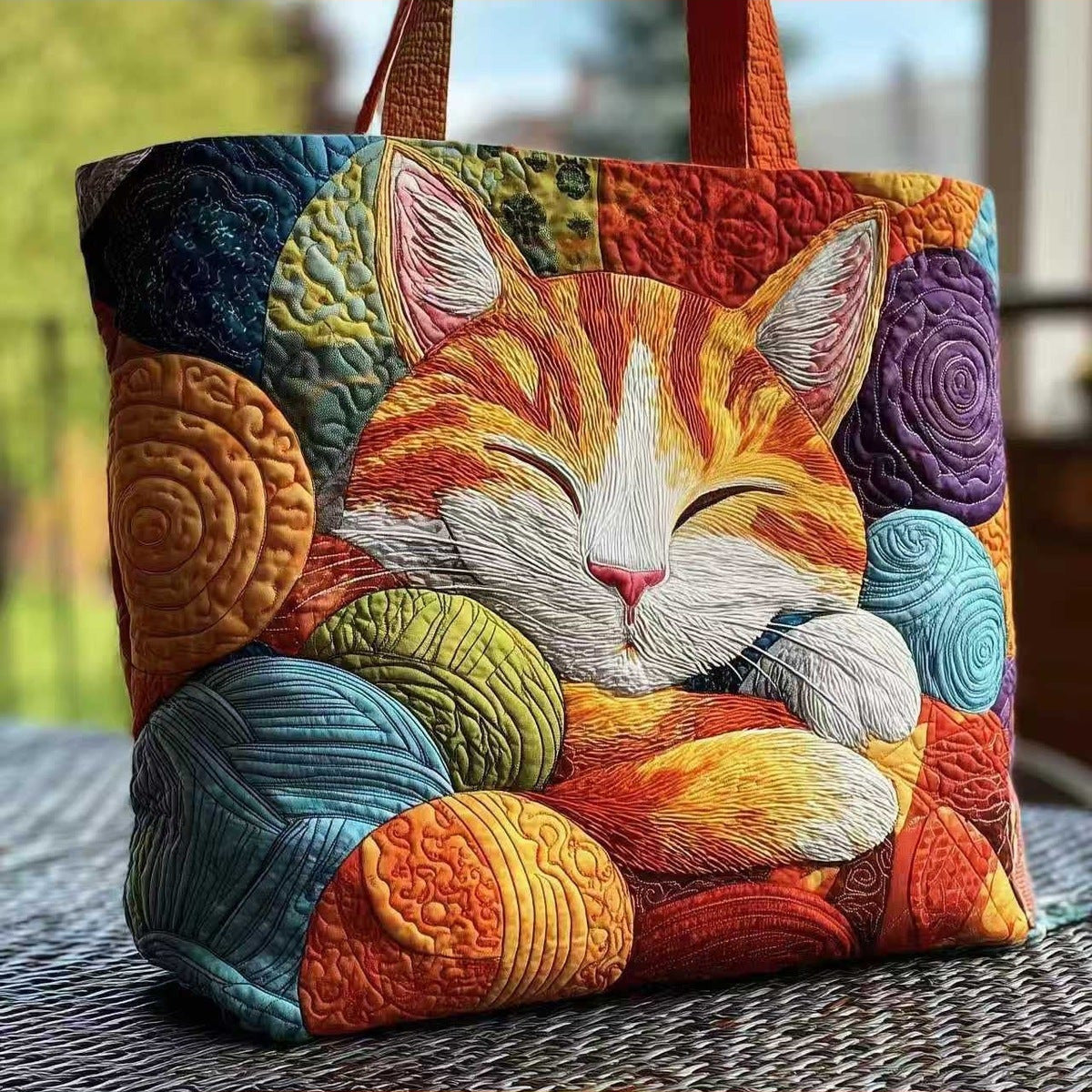 Bolso tote acolchado con gato naranja dormido entre ovillos de lana